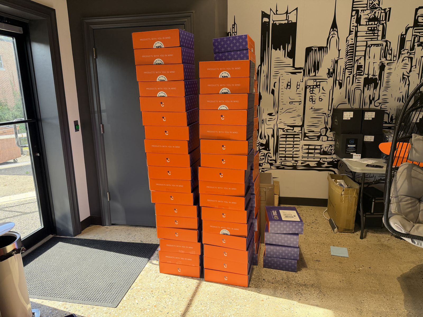 Tall stacks of orange care-package boxes in the office